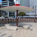 Petit banc et gros parasol sur pont imposant