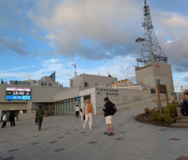 Une des zones ouvertes, avec son écran d'information et ses touristes assis
